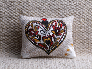 Cushion with heart shaped decoration on the sofa