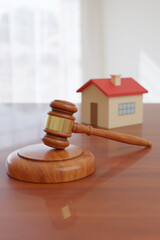 Wooden gavel and and house toy. Concept of real estate law. 3d illustration.