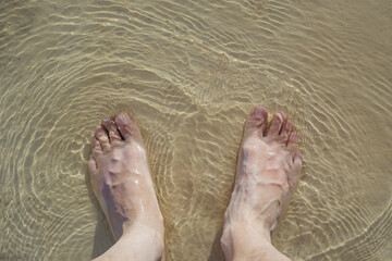 Top view of a man's feet in a swimming pool.