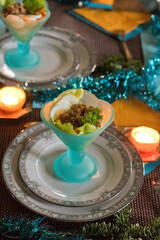 Festively served table, anticipation of Christmas, sea salad in turquoise bowls. High quality photo