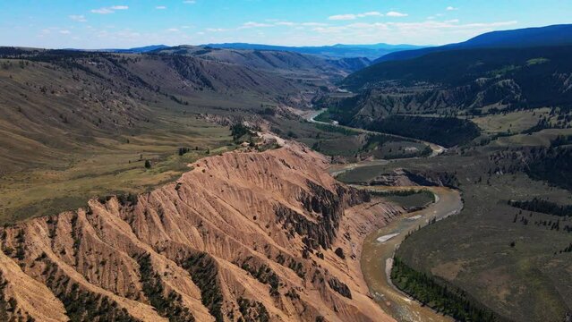 Aerial rotating view of Farwell Canyon, the chilcotin valley and river on a sunny day
