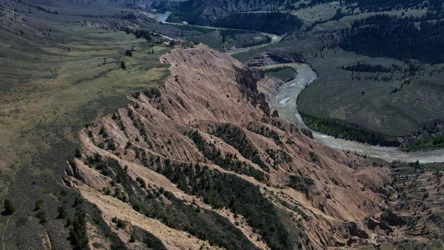 Aerial rotating view of Farwell Canyon, the chilcotin valley and river on a sunny day