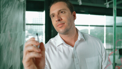 Portrait of professional male leader writing marketing idea on sticky notes. Caucasian businessman...