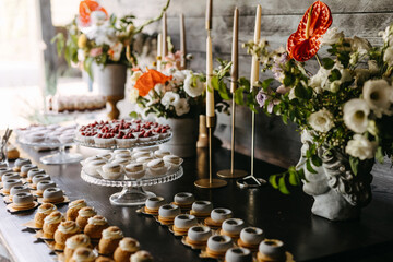 Dessert table at an event with macarons and tarts. Candy bar at a wedding.