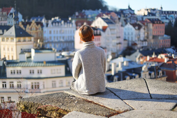 Boy sitting and look on the view of Karlovy Vary