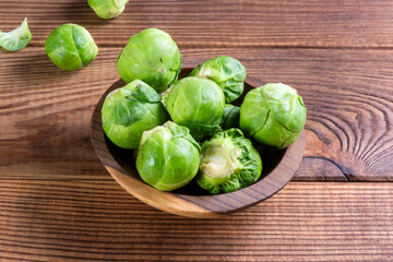 Fresh organic brussels sprouts raw in a plate on wooden background