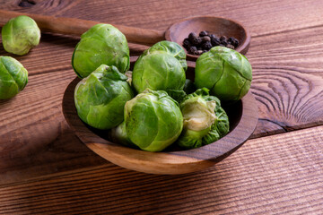 Fresh organic brussels sprouts raw in a plate on wooden background