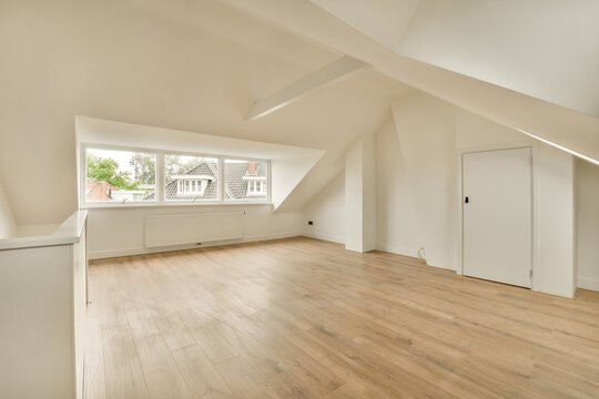 a living room with white walls and a large window