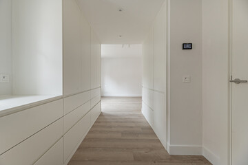 Hallway to a dressing room in a newly renovated bedroom with built-in wardrobes on both sides
