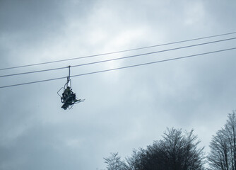 People in chairlift going up the mountain