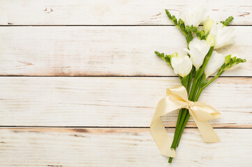 White freesia flower on wooden background, top view