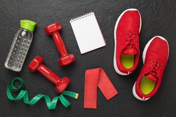 Sport equipment with tape measure on concrete background, top, view. Weight loss concept