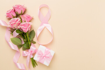 Composition with pink roses, gift box and eight made of ribbon on color background, top view. Women's day concept