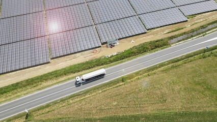 Truck Driving On The Highway Through Solar Farm. aerial