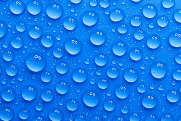 closeup, macro of many water drops, droplets, on a blue surface, background, a pair of eyes that...