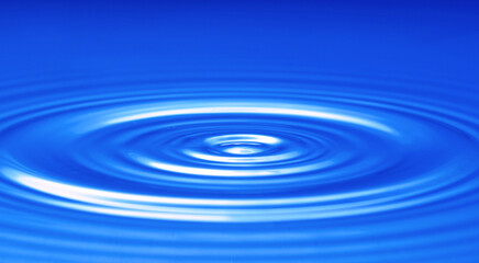 closeup, macro of circular waves on a water surface, caused by a falling water drop