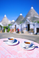 closeup of two cups of Espresso on a table, with empty street out of focus in background in Alberobello in preseason, Alberobello, Apulia, Italy, Europe