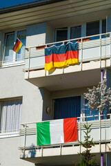 national flags of Germany and Italy fixed at balcony railings of a Revenue House, while soccer...