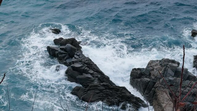 the constancy of a wave crashing into rocks 