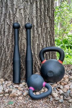 steel clubs and kettlebells in backyard, functional fitness and homer gym concept