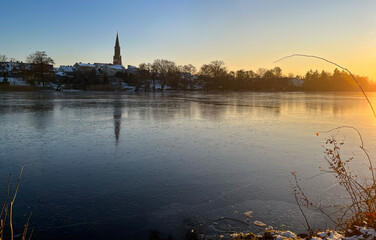 Fototapeta na wymiar Evening winter landscape. Frozen lake at sunset. Reflections on ice.