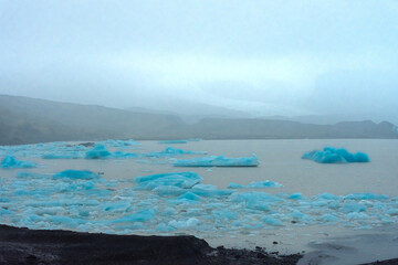 Icebergs from the melting Fjallsjokull Glacier under the rain,  Iceland