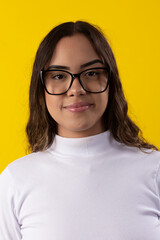 young woman wearing a white blouse and glasses on yellow background