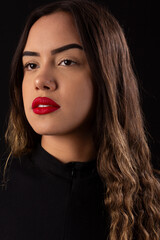 young woman with red lipstick wearing black clothes on a black background