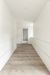 Hallway to a dressing room in a newly renovated bedroom with built-in wardrobes on both sides
