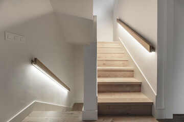 Stairs with oak wood steps with handrails with LED lights