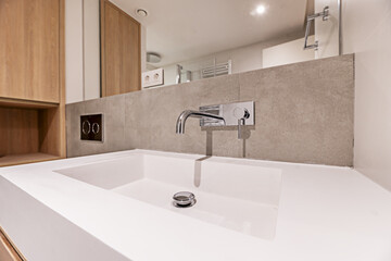 A white resin sink with a modern chrome faucet