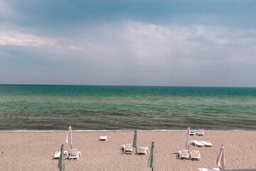 A beach with umbrellas and chairs