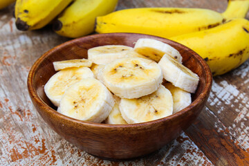 Bananas sliced in a wooden bowl close-up view 