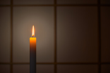 和室の障子の前で静かに燃える蝋燭