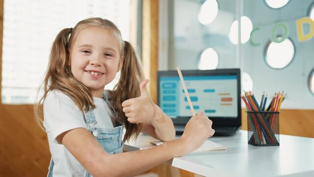 Cute student thinking while writing or doing homework by using laptop screen display engineering coding program or programing system. Girl thinking while turning around and showing thumb. Erudition.