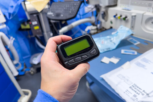 Vintage Pager On A Busy Desk, Symbolizing Hectic Work Life And Essential Communication In A Hospital Setting