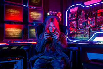 Asian woman live stream she play video game via smartphone at home neon lights living room, Gamer...