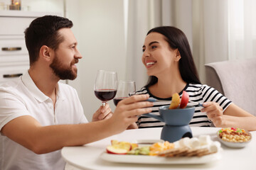 Affectionate couple enjoying chocolate fondue during romantic date at home