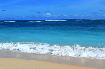 Empty clean sand beach with clear blue sea water to fresh your mind, environmental concept, summer outdoor day light, holiday and vacation destination. It is located in Bali.
