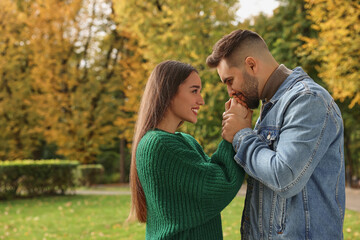 Fototapeta premium Romantic young couple spending time together in autumn park, space for text