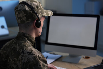 Military service. Soldier in headphones working in office, space for text - obrazy, fototapety, plakaty