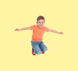 Happy boy jumping on beige background, full length portrait