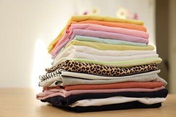 Stack of clean clothes on wooden table