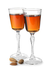 Liqueur glasses with tasty amaretto and almonds isolated on white