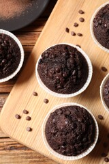 Tasty chocolate muffins on wooden table, flat lay