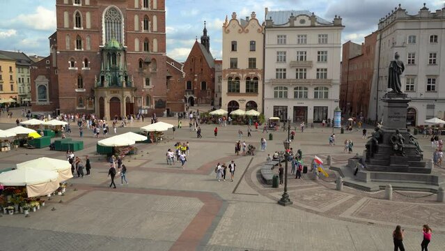 Tourists visiting the Old Town Main Market Square in the center of Krakau, Poland. The famous St. Mary's Basilica in Krakow. View of Krakow historic market square, Poland, central Europe