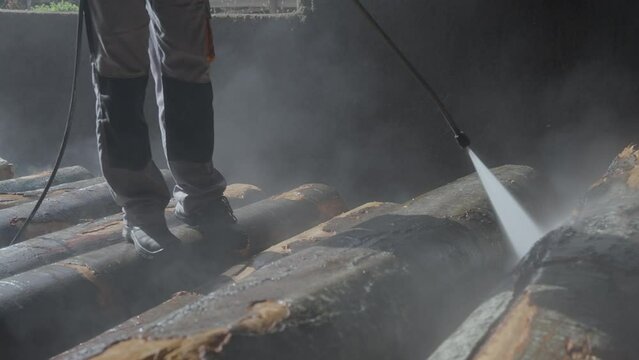 Carpenter cleaning and washing tree log