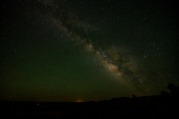 Fototapeta na wymiar Faint City Lights On The Horizon Over Bryce Canyon With The Milky Way Over Head