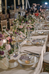 long table setting with multi color flower arrangement for wedding decoration and private party with family in a sunny day outdoors