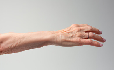 Hand of an elderly woman on light gray background. An open hand.